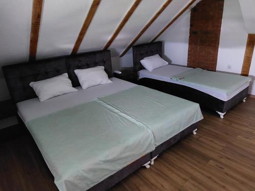 two twin beds in a room with wood floors at Apartments Alibasic in Dubrave Gornje