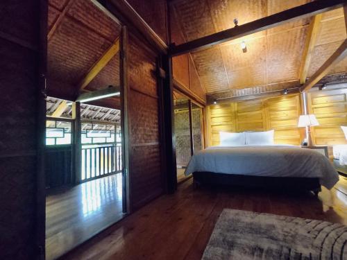 a bedroom with a bed in a room with wooden walls at Thavill Retreat HaGiang in Ha Giang