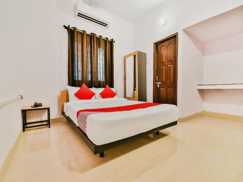 a bedroom with a large bed with red pillows at Super Hotel O Capital Pearl in Patna