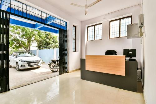 an office with a desk and a car parked in a garage at OYO Flagship Ag Colony in Patna