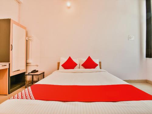 a red and white bed with red pillows on it at Super Hotel O Capital Pearl in Patna