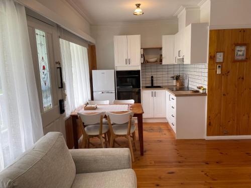 eine Küche mit einem Tisch und Stühlen im Zimmer in der Unterkunft Sandpiper - charming beach villa in Port Fairy