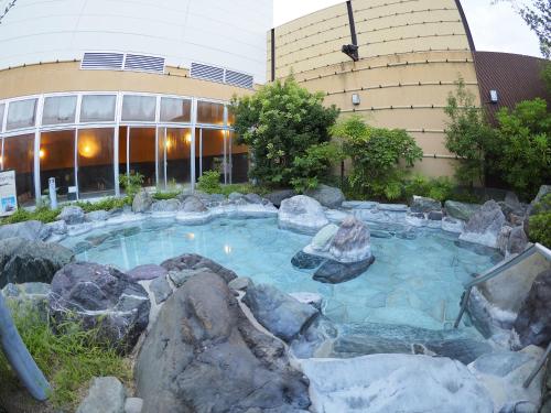 a swimming pool with rocks in front of a building at Castle Inn Toyokawa in Toyokawa
