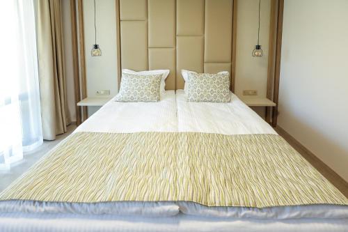 a bedroom with a large white bed with two pillows at Hotel Green Park Service Perfected in Garmen