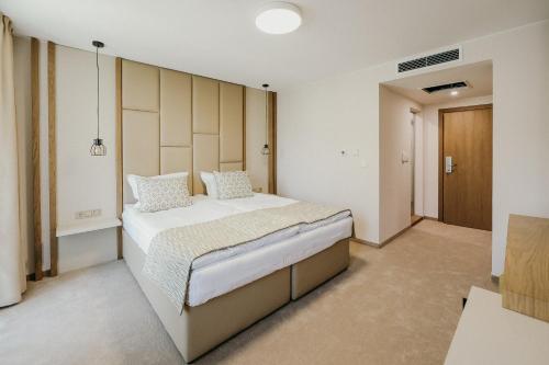 a bedroom with a large bed in a room at Hotel Green Park Service Perfected in Garmen