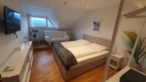 um pequeno quarto com uma cama e uma cadeira em Lakeside Hills Apartment, Appartement em Krumpendorf am Wörthersee