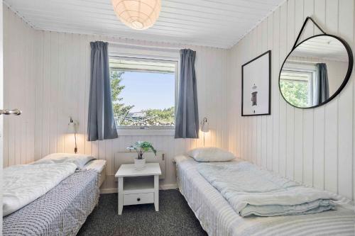 2 camas en una habitación con espejo y ventana en Solsorten, en Hasle