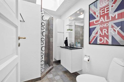 uma casa de banho com WC e uma pintura na parede em Solsorten em Hasle