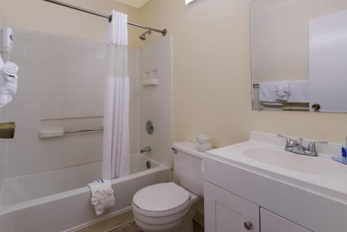 a white bathroom with a toilet and a sink at Rodeway Inn Livermore in Livermore