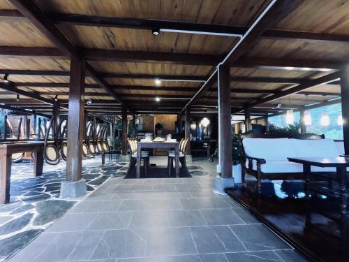 a patio with tables and chairs and a wooden ceiling at Thavill Retreat HaGiang in Ha Giang