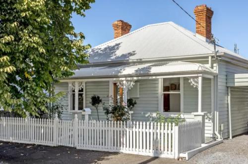 a white house with a white picket fence at Tranquil Launceston Getaway - You'll fall in love! in Launceston