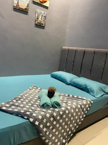 Una cama con dos almohadas y una planta. en Hotel Tangga Batu en Tangga Batu