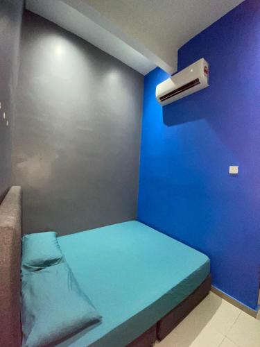 Habitación azul pequeña con cama y aire acondicionado en Hotel Tangga Batu, en Tangga Batu