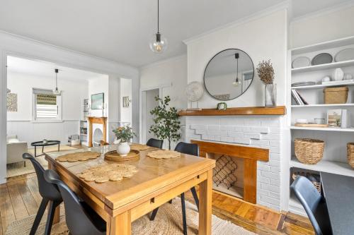 a dining room with a table and a fireplace at Tranquil Launceston Getaway - You'll fall in love! in Launceston