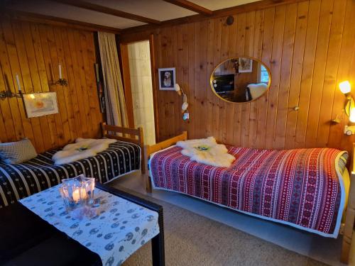 阿德爾博登的住宿－Chalet Gotthelf Gartenstudio, Ferien mit Hund，一间卧室配有两张床、一张桌子和一面镜子