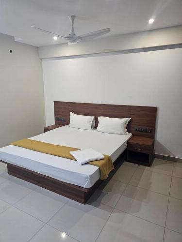 a bedroom with a large bed with a wooden headboard at Uptown Inn in Ernakulam