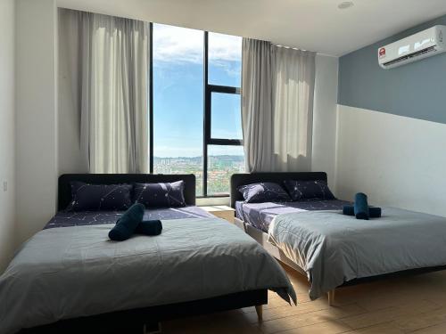 um quarto com 2 camas e uma grande janela em ITCC Manhattan Suites by Stay In 5-6pax em Donggongon