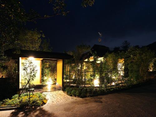 a house with lights on the side of it at night at kominka neri（古民家煉り） in Miyawaka