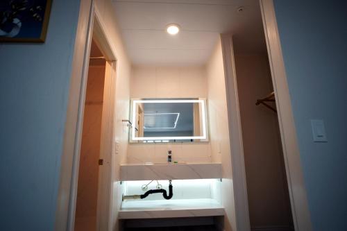 uma casa de banho com um lavatório branco e um espelho. em Airport Stay Motel em Ontario