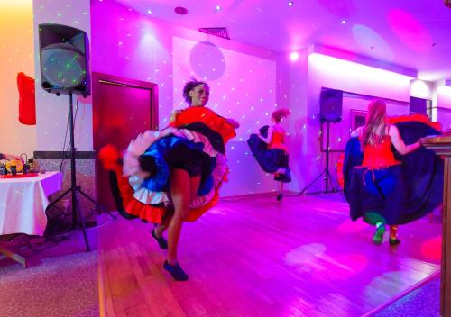 a group of people dancing in a room with pink lights at Pavlo Napa Beach Hotel in Ayia Napa