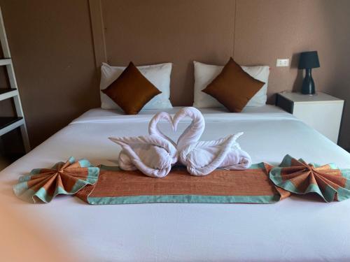 two towelsrendered to look like swans on a bed at Uphill Cottage in Phi Phi Islands