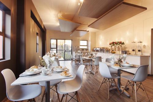 ein großes Esszimmer mit Tischen und Stühlen in der Unterkunft Akanani Apartments in Pretoria