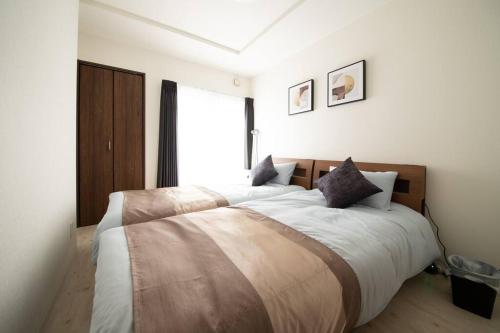 um quarto com uma cama grande e uma janela grande em Otaru SAMPO em Otaru