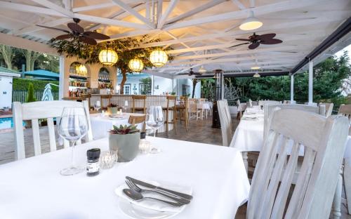 a restaurant with white tables and chairs and a ceiling at Shandon Lodge Guest House & Spa in Nelspruit