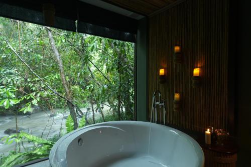 uma banheira na casa de banho com uma janela em Nampien Yorla Pa 