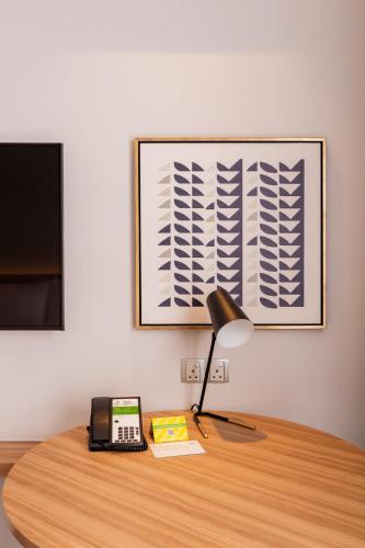 a desk with a phone and a lamp on it at Holiday Inn Sepang - Airport in Sepang