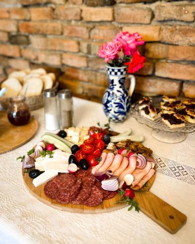 a plate of meats and vegetables on a table at Castle View Saschiz - Traditional Guesthouse in Saschiz