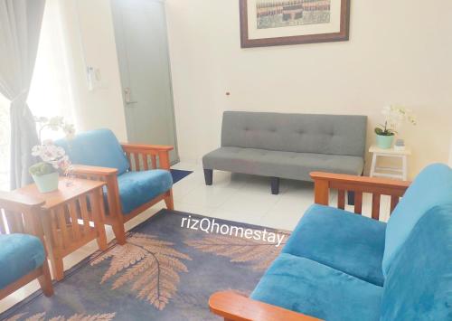 a living room with blue chairs and a couch at RizQ Homestay Tg Malim in Kerling