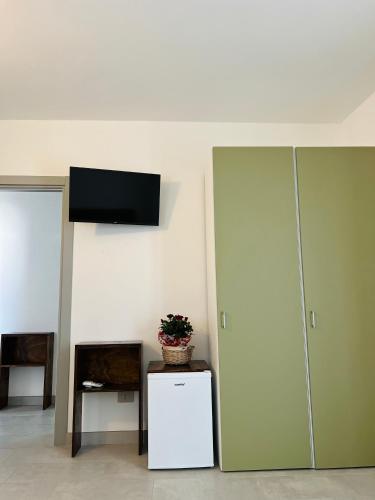a room with a refrigerator and a tv on a wall at La Ringhiera in Novara
