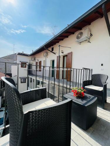 - un balcon avec des chaises et des tables en osier dans un bâtiment dans l'établissement La Ringhiera, à Novara