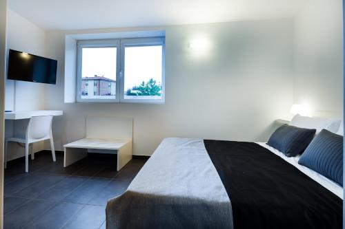 a bedroom with a bed and a desk and a window at Residence Peloni in Arezzo