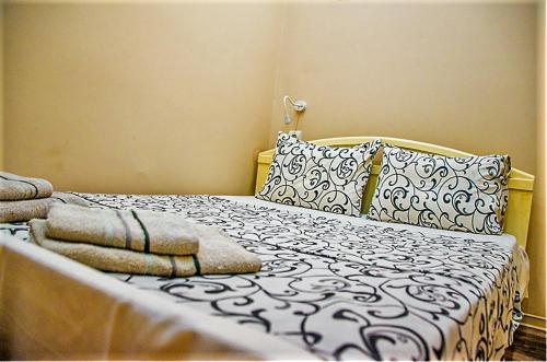 a bed with a black and white comforter and pillows at smart Travellers in Thessaloniki