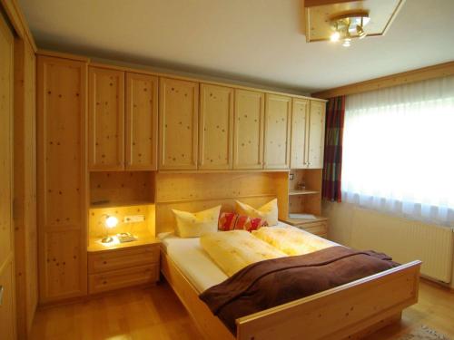 a bedroom with a large bed with wooden cabinets at Great holiday home in Hippach with sunny terrace in Hippach