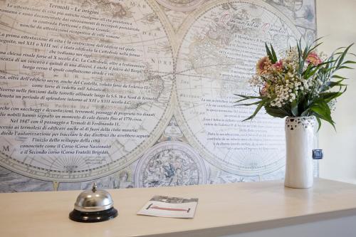 a vase of flowers on a table with a wall at Quarantadue Quindici in Termoli
