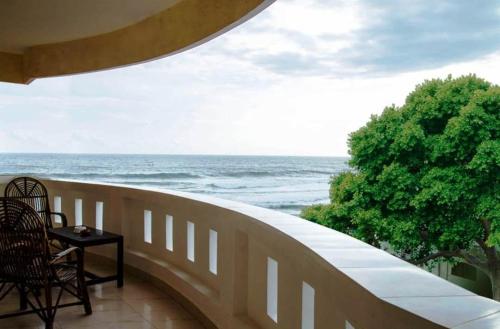 a balcony with a table and a view of the ocean at Hawah Beach Resort Kovalom in Kovalam