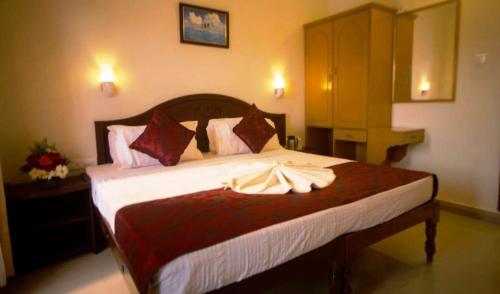 a bedroom with a large bed with white sheets at Hawah Beach Resort Kovalom in Kovalam