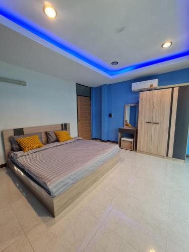 Schlafzimmer mit einem großen Bett und blauen Decken in der Unterkunft Noc House in Bang Khlo