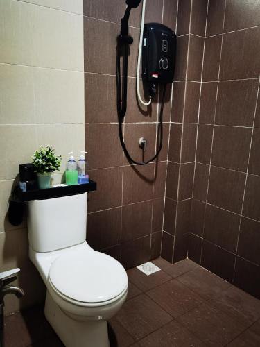 a bathroom with a shower with a toilet and a phone at Bandar Melaka Family Bungalow Private Pool BBQ WiFi Netflix in Melaka