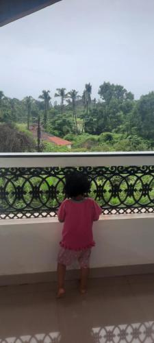 a little girl looking out of a window at the forest at Eve Resort in Patnem