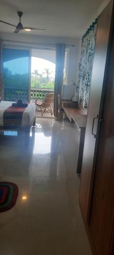 a bedroom with a bed and a desk and a window at Eve Resort in Patnem