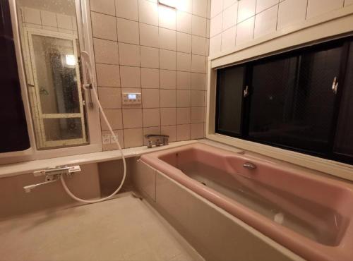 a pink bath tub in a bathroom with a window at Ahouse - Vacation STAY 17245v in Takashima