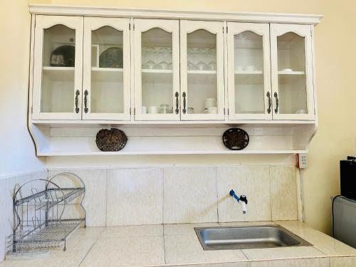 a kitchen with white cabinets and a sink at Paragua House in Taytay