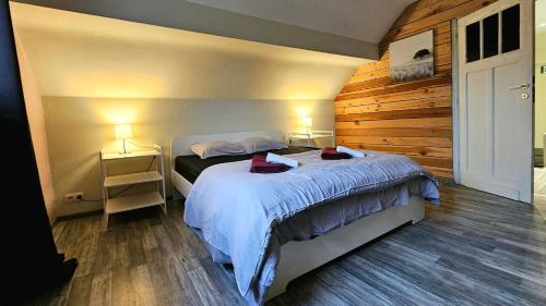 a bedroom with a bed and two lamps on two tables at "Petit Durbuy" by Phils Cottages in Durbuy