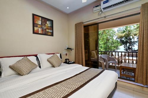 una camera con un grande letto e un balcone di Wairkar’s Sea Pearl Resort a Malwan
