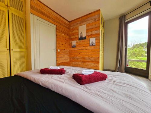 two red pillows on a large bed in a room at "Petit Durbuy" by Phils Cottages in Durbuy