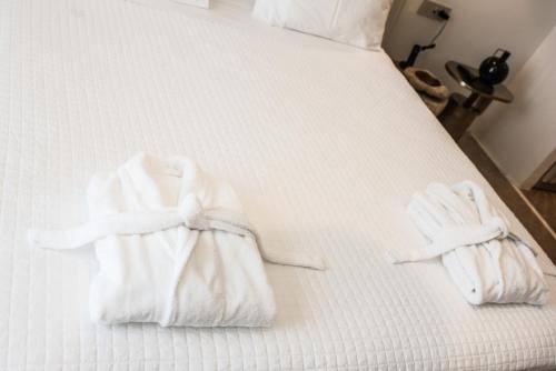 two towels are sitting on a bed at Νumi Boutique Hotel in Mýkonos City